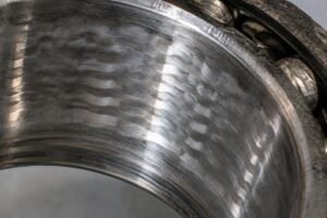 Close-up view of electrical fluting damage on a bearing inner race showing characteristic washboard pattern